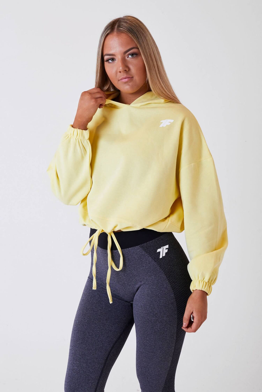 A woman wearing True Form's Lemon Women's Oversized Crop Hoodie for Gym Wear