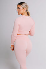 Load image into Gallery viewer, A model facing sideward wearing true form pink long sleeve top and leggings

