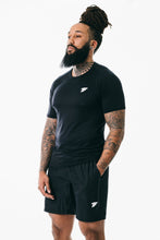 Load image into Gallery viewer, A man facing sideward wearing true form black T-shirt and black shorts
